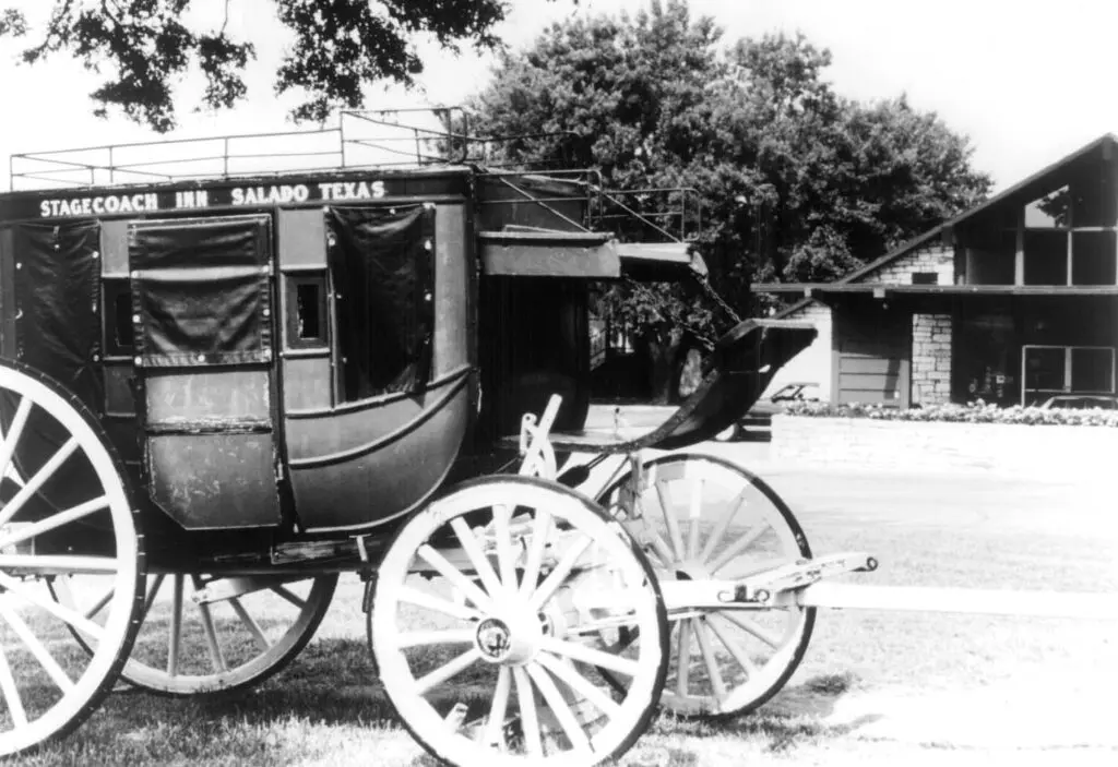 Historic stagecoach wagon outside the Stagecoach Inn in Salado, Texas, with the inn building in the background.