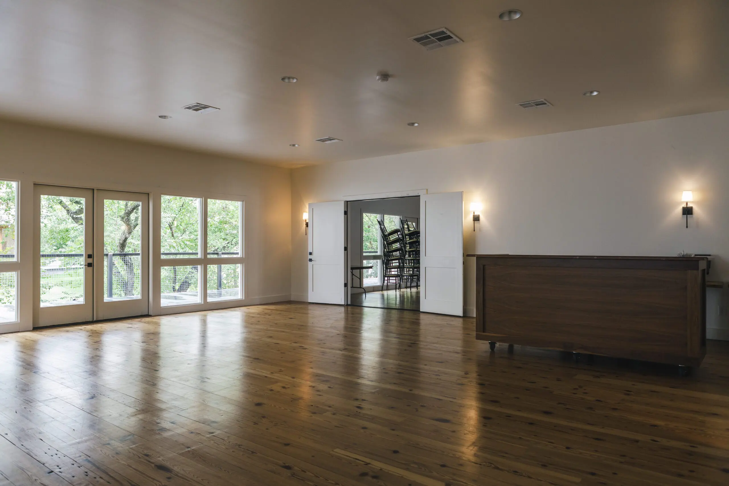 Spacious event room with hardwood floors and large windows at Stagecoach Inn.
