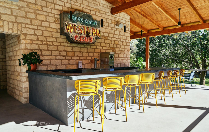 Sirena’s Cantina at Stagecoach Inn with yellow bar stools and a neon sign reading 'Stagecoach Western Club'.