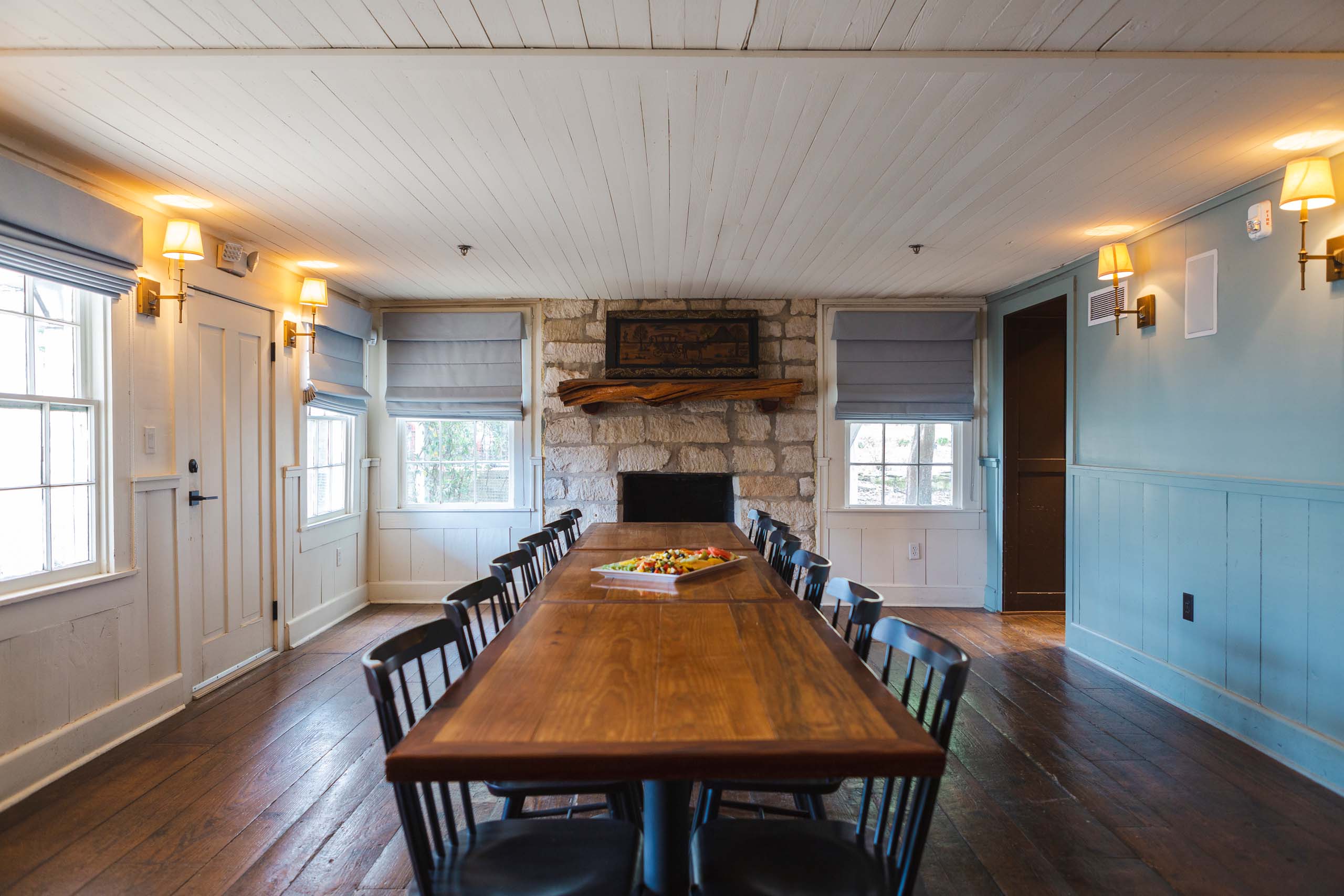 Dining room with a long wooden table and stone fireplace at Stagecoach Inn.