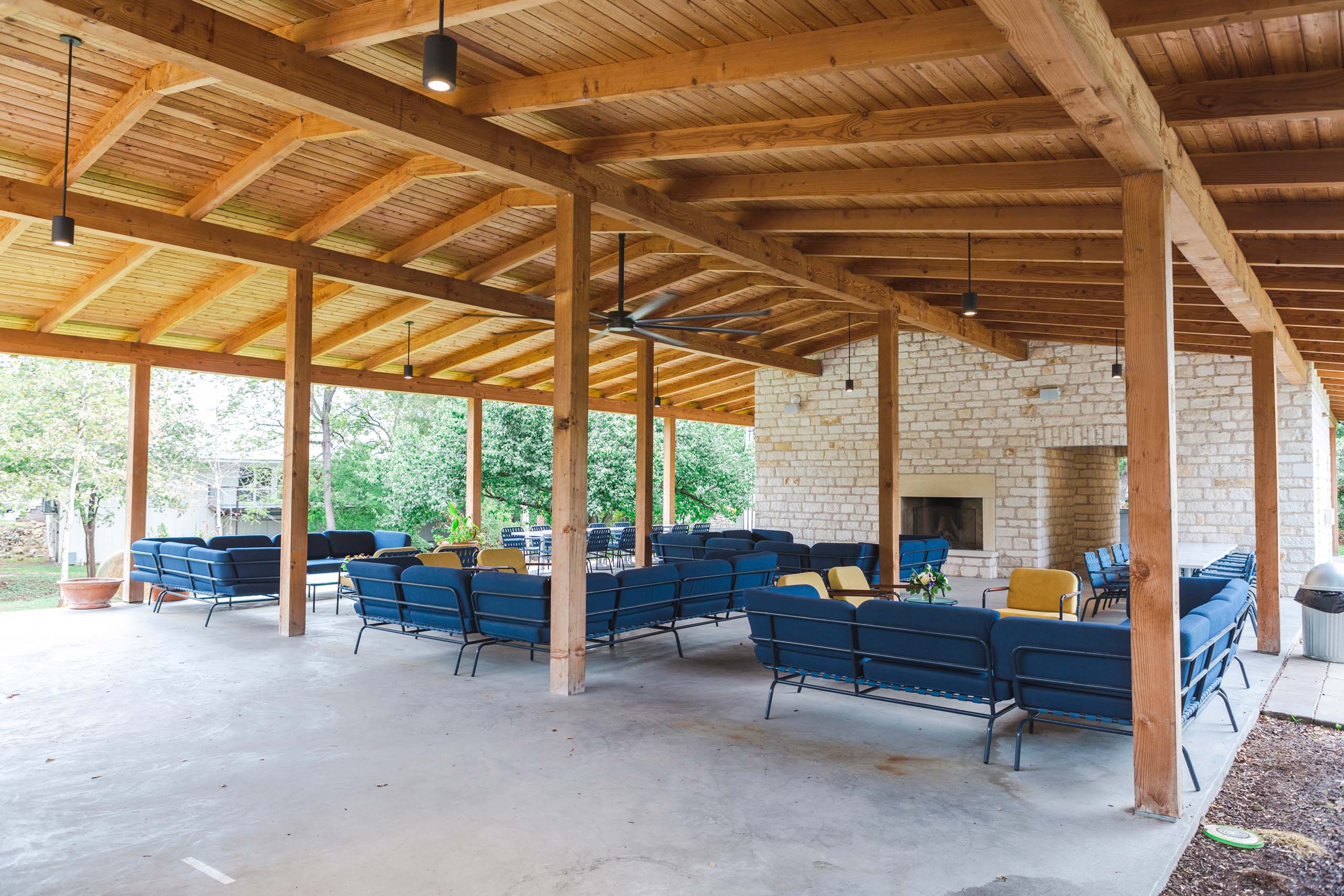 Outdoor pavilion with blue seating and wooden beams at the Stagecoach Inn in Salado, Texas.