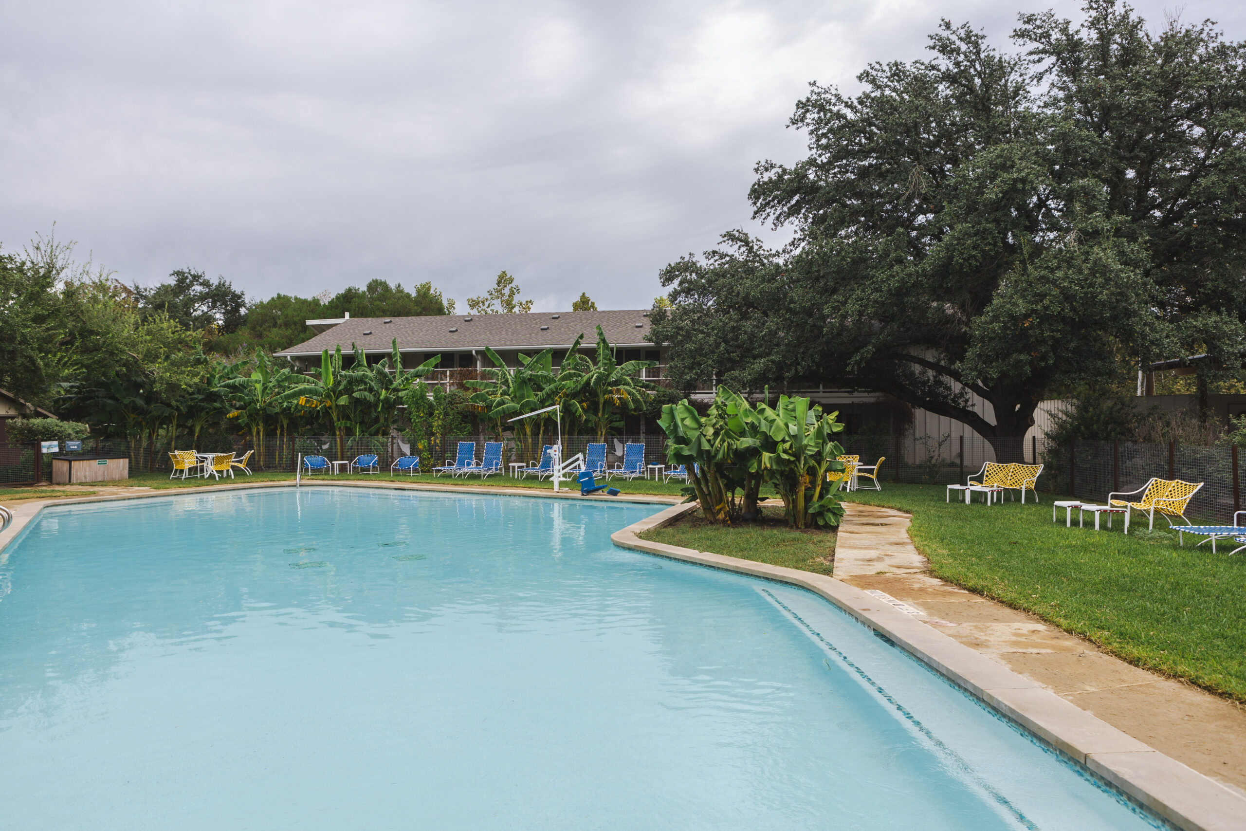 Inviting pool area with lounge chairs and tables at the Stagecoach Inn in Salado, Texas.